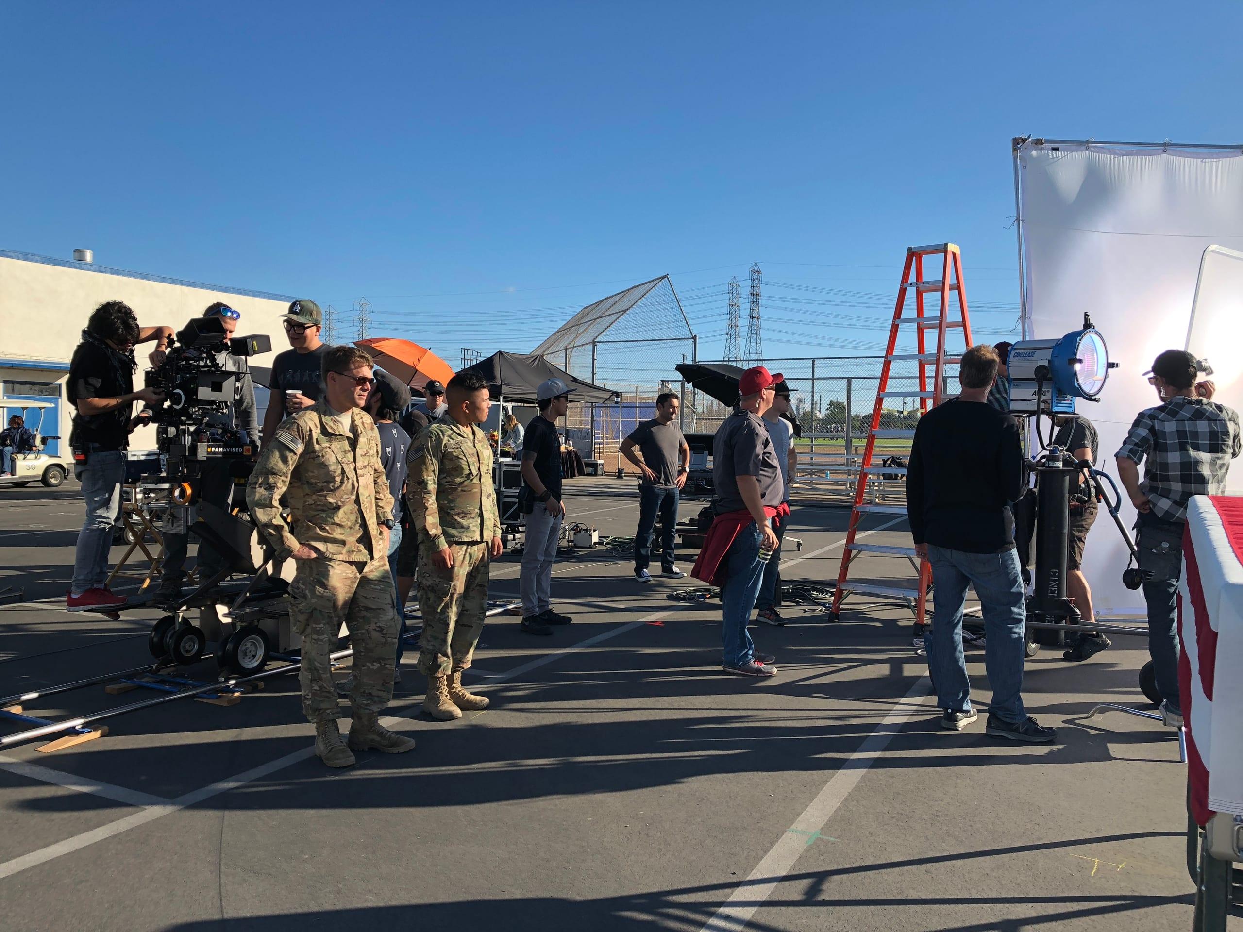 A camera crew and cast in military costume working a scene on location
