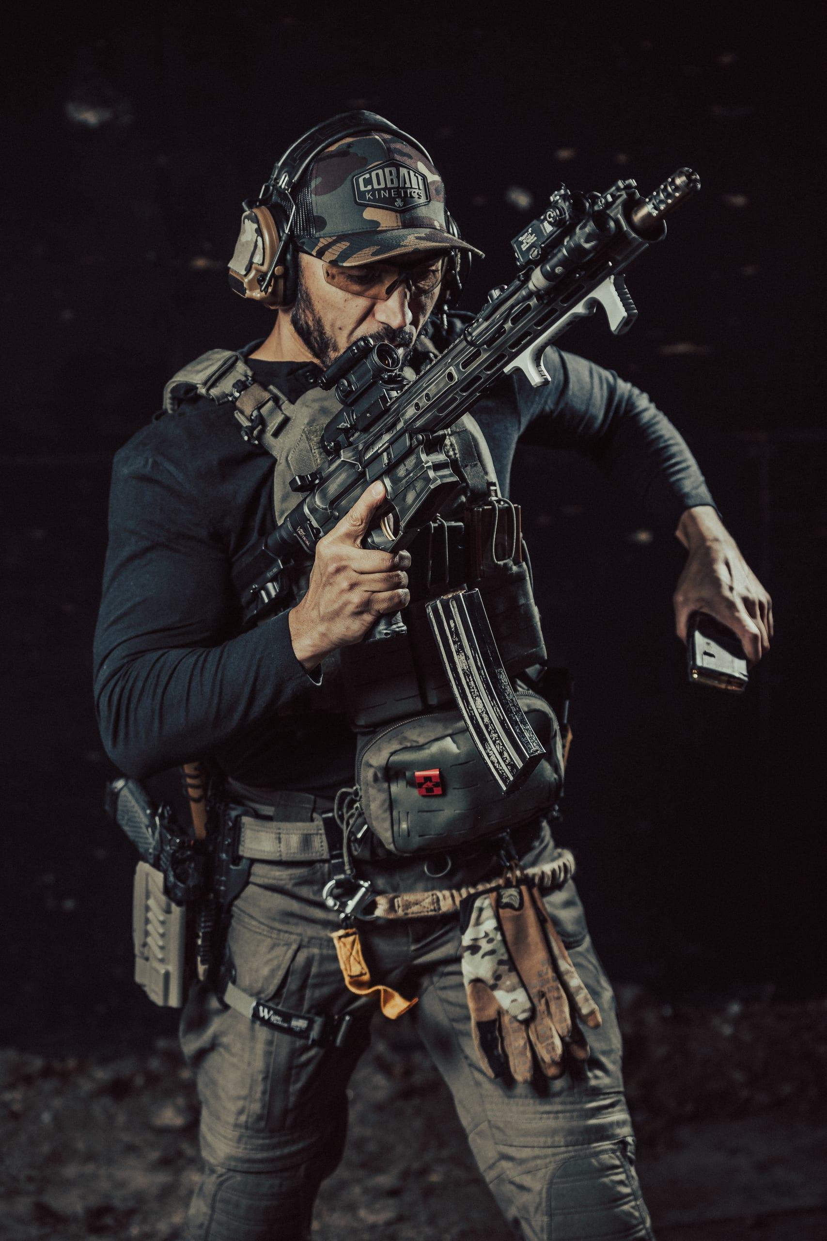 A shooter firing a carbine with brass mid-ejection