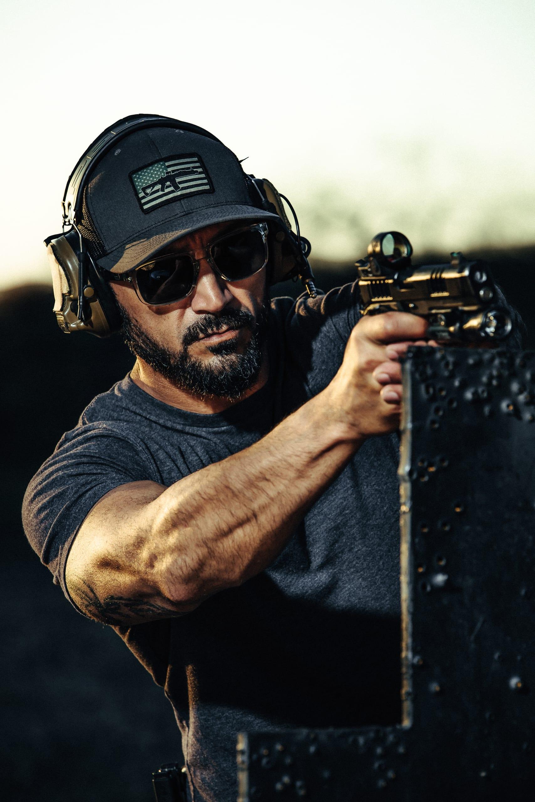 A shooter presenting a pistol, shot tight on the grip and sights